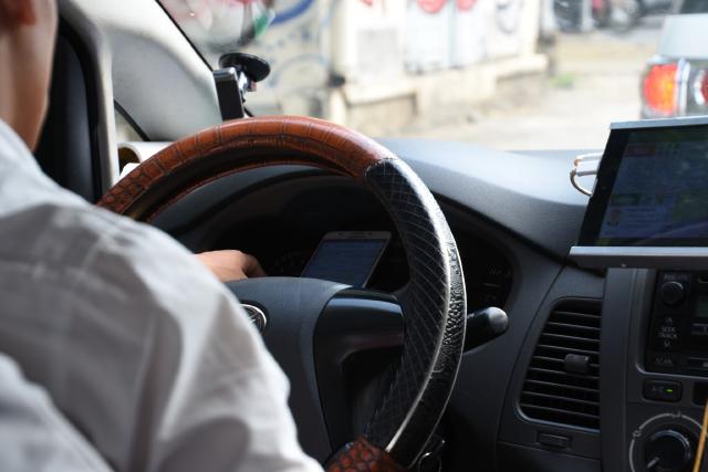 Taxi driver using mobile phone (yes, this is normal - even on a bike while holding a smoke in the other hand)